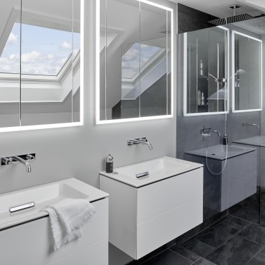 Cuarto de baño bajo techo con dos lavabos y espejos