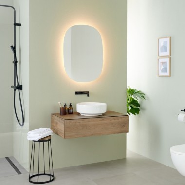Espejo ovalado Geberit Option con lavabo sobre encimera y muebles del baño VariForm