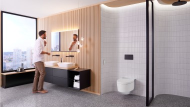 Hombre en el baño frente al espejo Geberit Option Plus Square y el mueble de baño negro Geberit ONE (© Geberit)