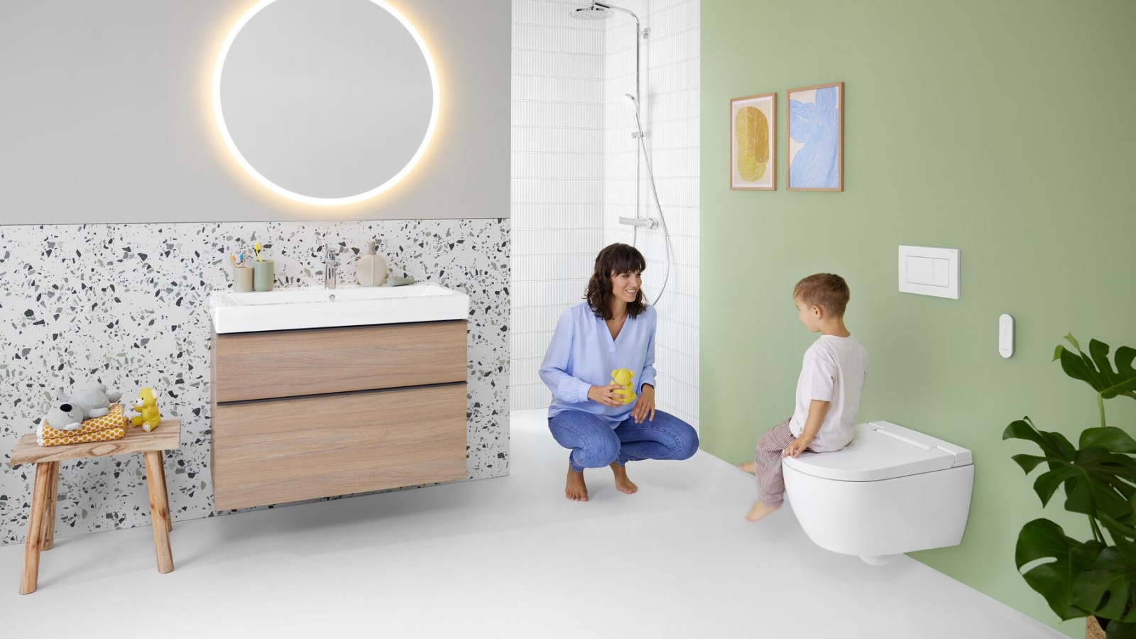 Mujer y niño en un colorido baño con espejo Geberit Option y Geberit AquaClean Alba Mujer y niño en un colorido baño con espejo Geberit Option y Geberit AquaClean Alba