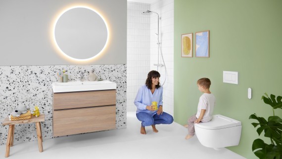 Mujer y niño en un colorido baño con espejo Geberit Option y Geberit AquaClean Alba Mujer y niño en un colorido baño con espejo Geberit Option y Geberit AquaClean Alba