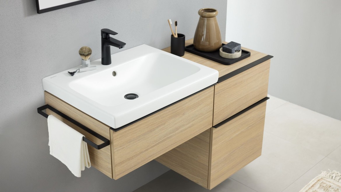 Zona de lavabo con lavabo sobre encimera Geberit iCon en blanco mate y accesorios de baño en negro mate