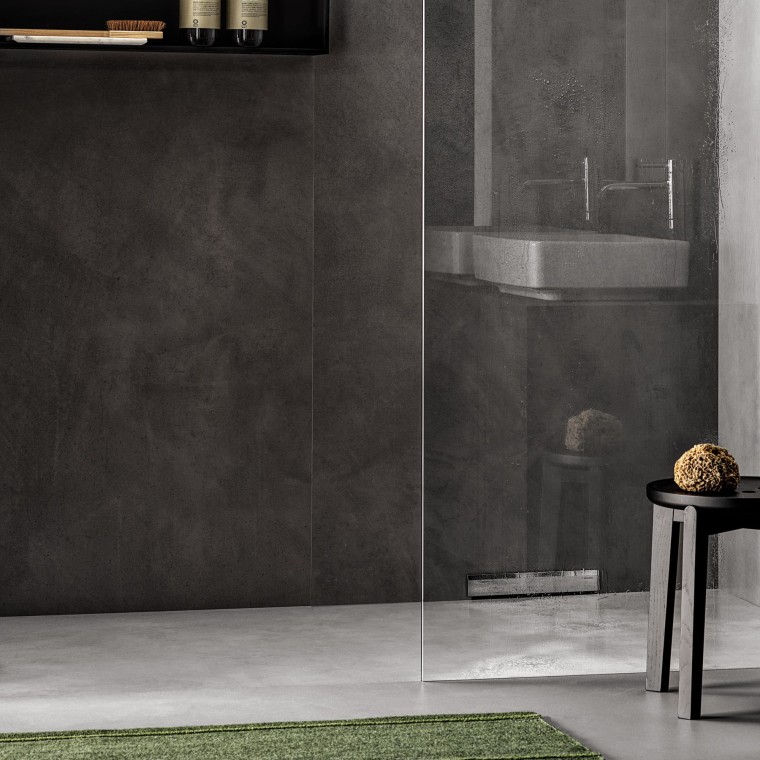 Una ducha a ras de suelo con desagüe en la pared