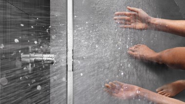 Persona duchándose en una ducha a ras de suelo con canal de ducha CleanLine (© Geberit)