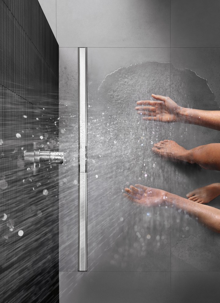 Persona duchándose en una ducha a ras de suelo equipada con el canal de ducha Geberit CleanLine
