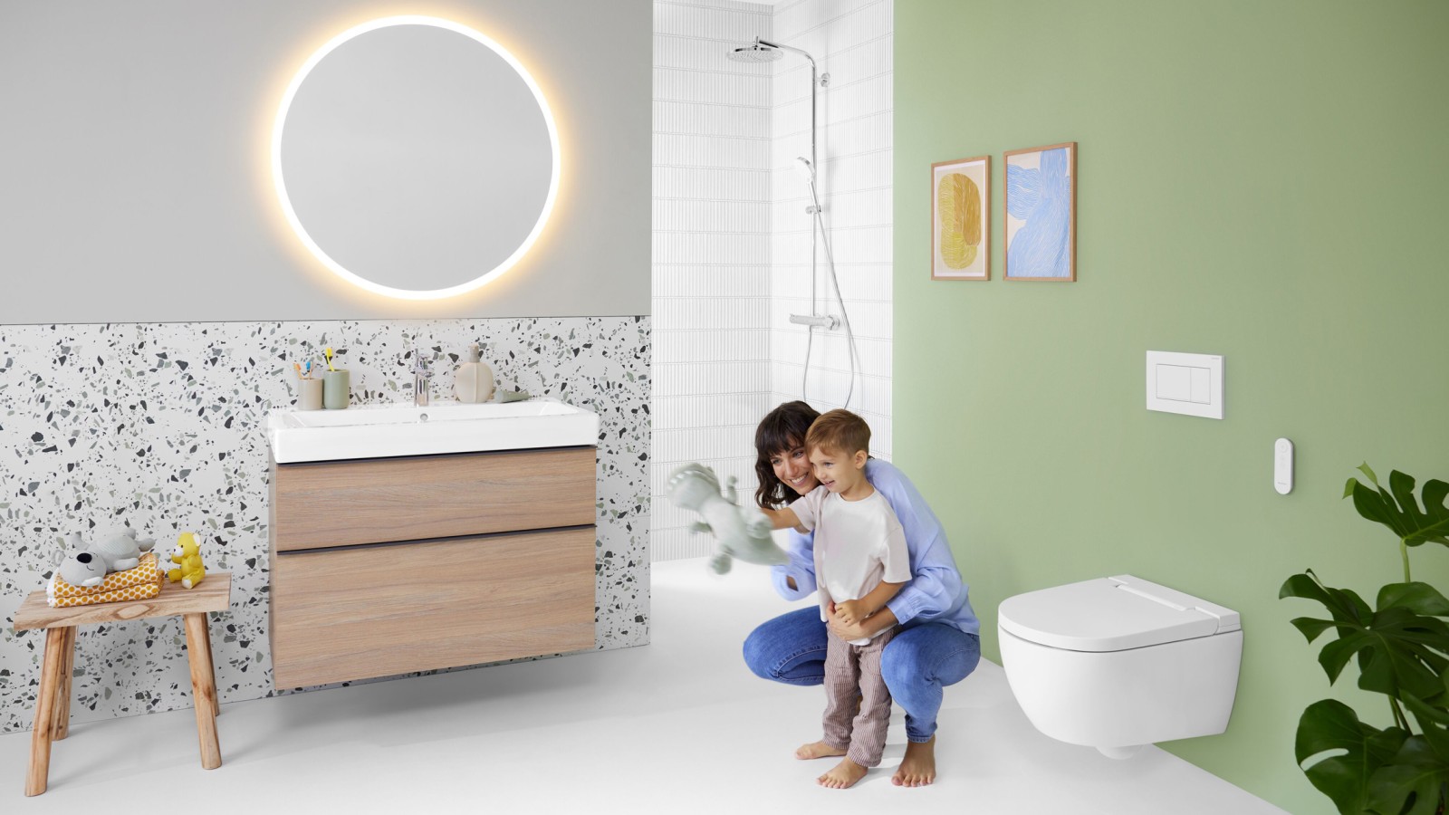 Geberit AquaClean Alba con una mujer y un niño en el baño Geberit AquaClean Alba con una mujer y un niño en el baño