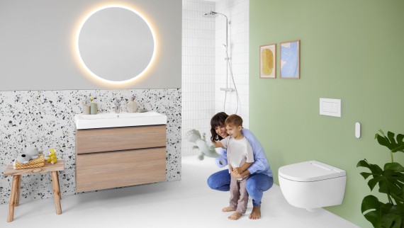 Geberit AquaClean Alba con una mujer y un niño en el baño Geberit AquaClean Alba con una mujer y un niño en el baño
