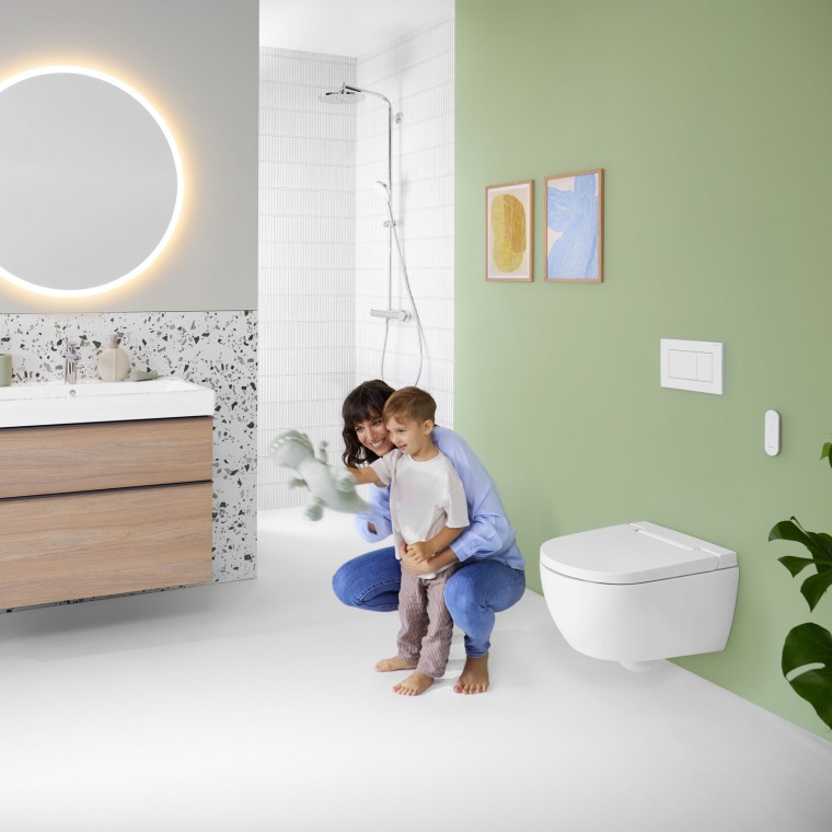 Mujer y niño en un colorido baño con espejo Geberit Option