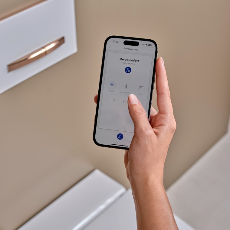 Una mujer utiliza la aplicación Geberit Home en un smartphone Una mujer utiliza la aplicación Geberit Home en un smartphone