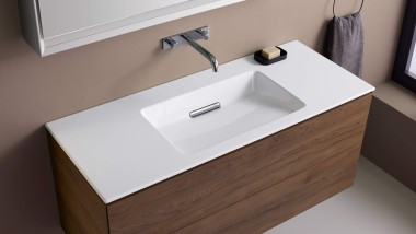 El lavabo Geberit ONE con borde delgado y mueble de nogal.
