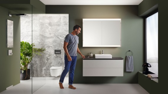 Hombre en un baño Geberit con ducha a ras de suelo
