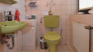 El baño de invitados verde de los años 80 antes de la renovación.