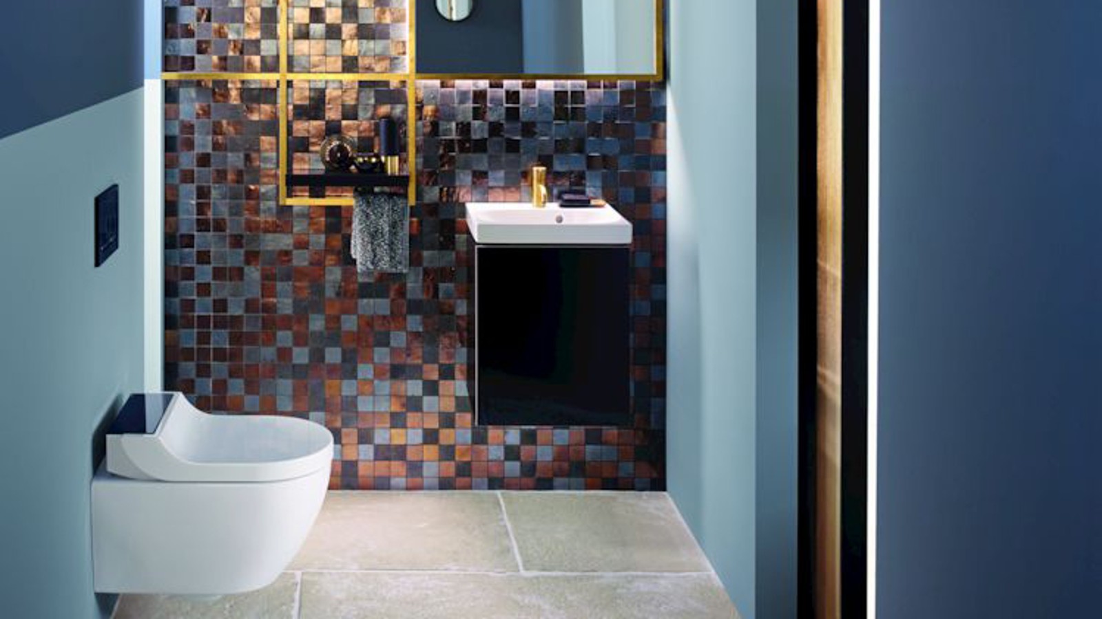 Los tonos dorados y cobrizos aportan calidez a este aseo de invitados