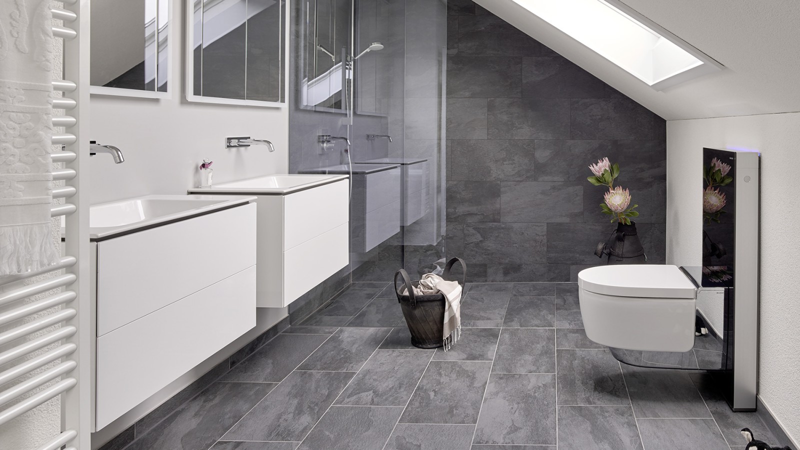 Baño con techo inclinado y productos de la serie de baño Geberit ONE y Geberit AquaClean con Monolith Baño con techo inclinado y productos de la serie de baño Geberit ONE y Geberit AquaClean con Monolith