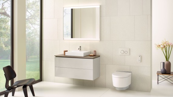 Baño blanco con armario con espejo, mueble bajo para lavabo, pulsador y cerámica sanitaria de Geberit