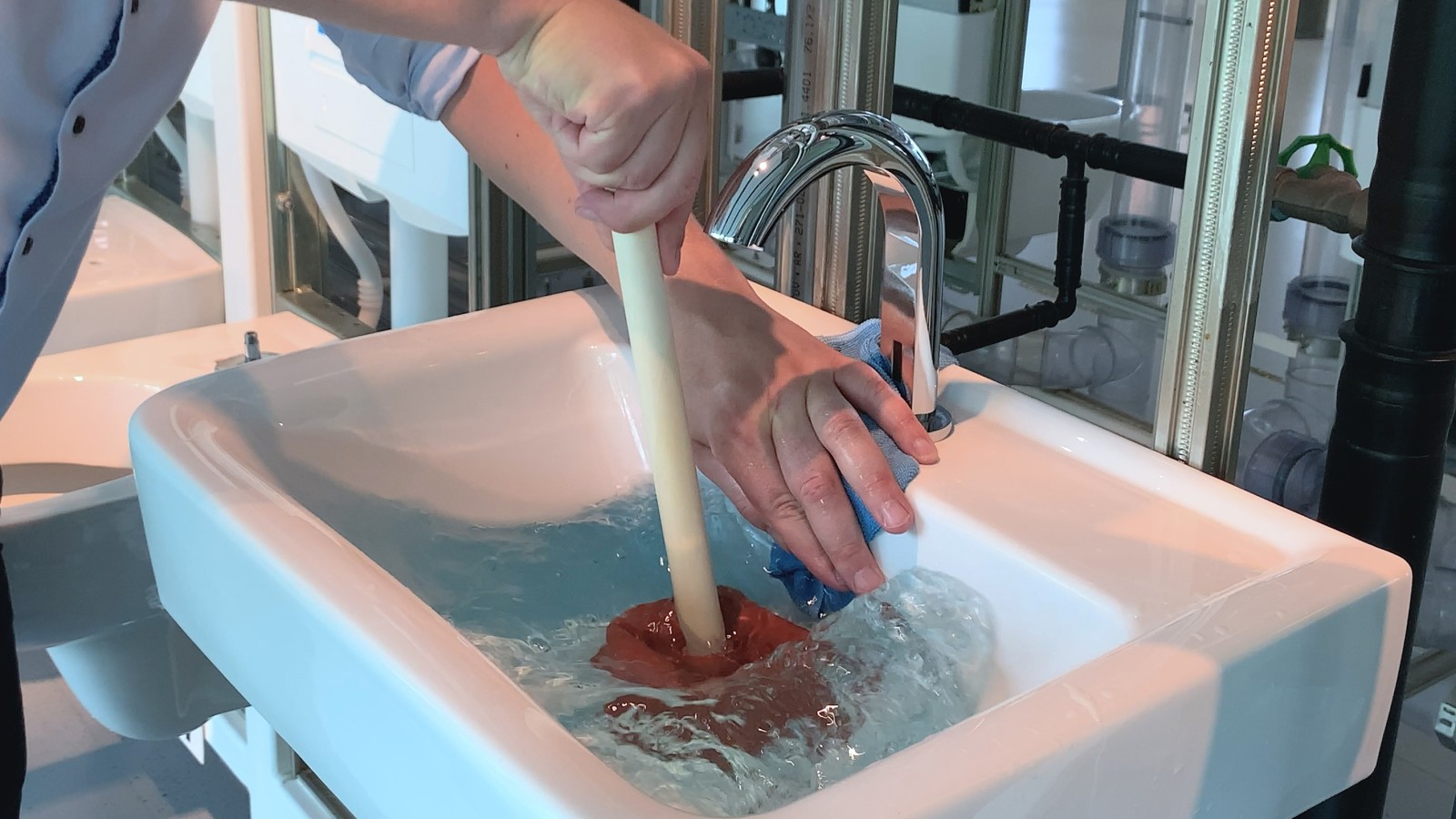 Se cubre el orificio del rebosadero con la mano y un trapo. Se cubre el orificio del rebosadero con la mano y un trapo.