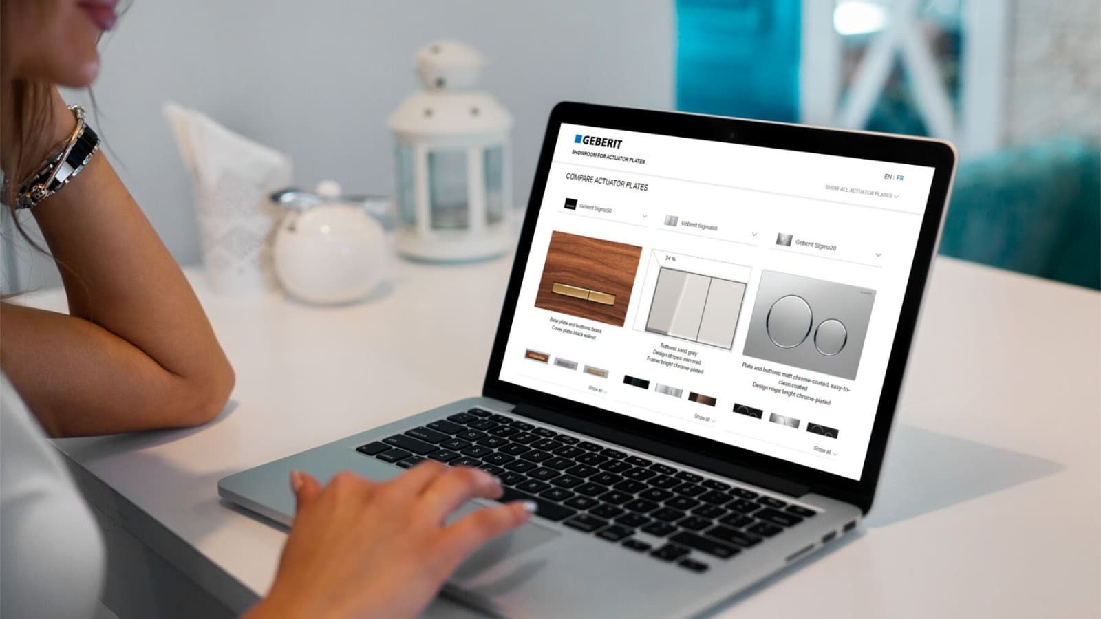 Mujer pone en marcha la exposición de pulsadores Geberit en su ordenador portátil Mujer pone en marcha la exposición de pulsadores Geberit en su ordenador portátil