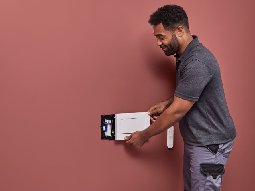 Hombre instalando la unidad de eliminación de olores Geberit DuoFresh Hombre instalando la unidad de eliminación de olores Geberit DuoFresh