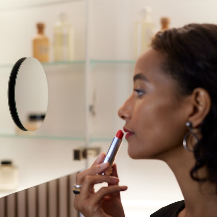 Mujer maquillándose en el espejo Mujer maquillándose en el espejo